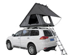 Load image into Gallery viewer, DesertX Trailblazer grey two-person hard shell rooftop tent set up on a white SUV with ladder extended.