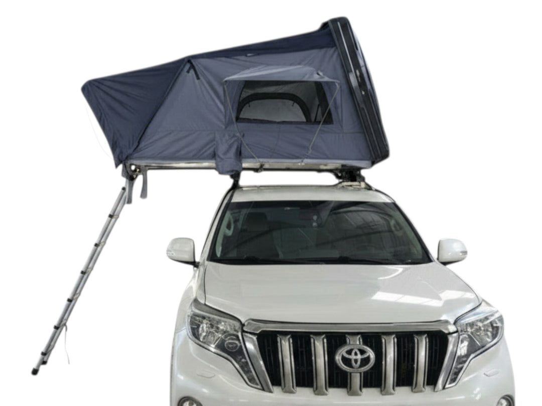 DesertX Basecamp dark grey hardshell rooftop tent mounted on a white SUV, with an extended ladder.