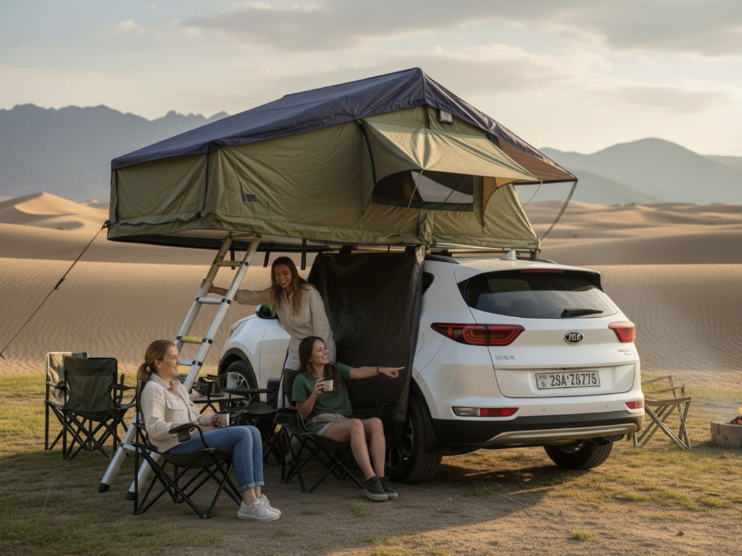 DesertX Nomad Plus rooftop tent on a white SUV, with a blue and green canvas, set up for camping with two people relaxing in chairs.